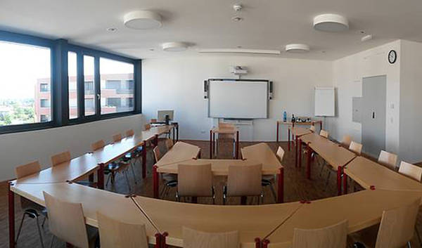 Seminarraum mit in U-Form aufgestellter Tischgruppe 